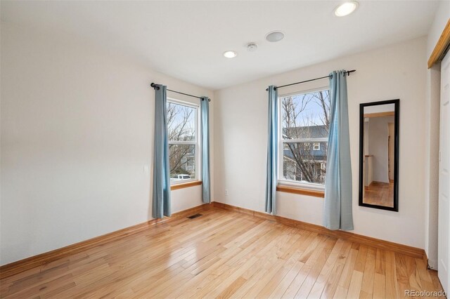 empty room with recessed lighting, light wood-style floors, baseboards, and visible vents