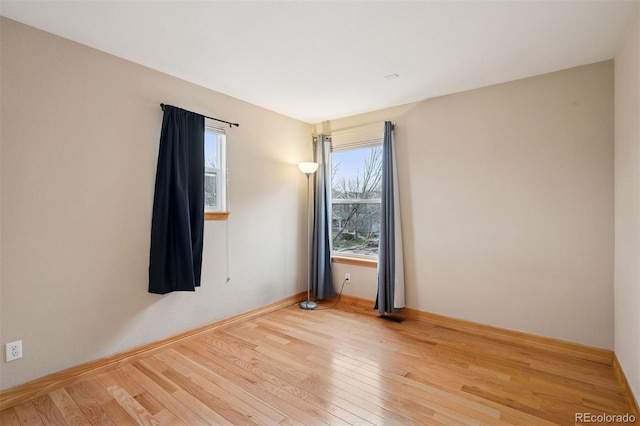 empty room with baseboards and hardwood / wood-style floors