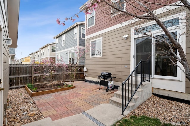 view of patio with a garden, fence, and area for grilling