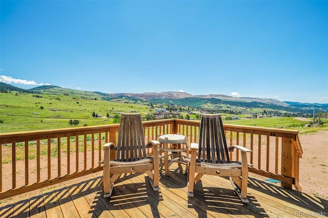 wooden deck with a rural view and a mountain view