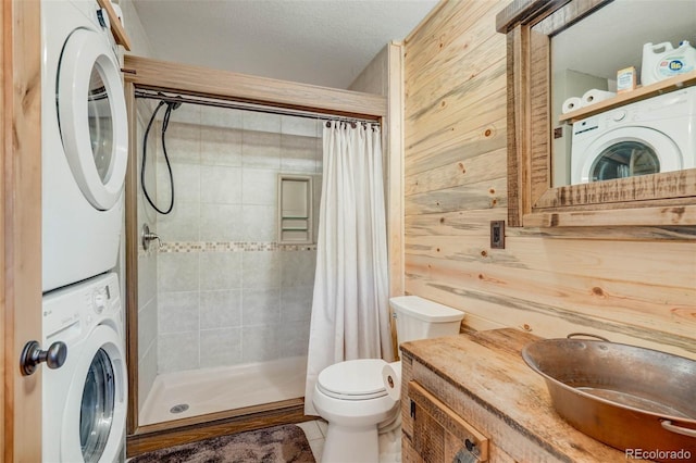 bathroom with stacked washer / dryer, wood walls, a shower with curtain, and a textured ceiling