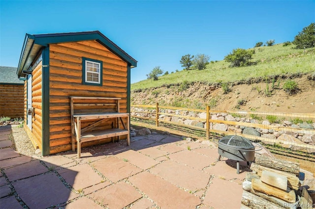 view of patio / terrace with a storage unit and a fire pit