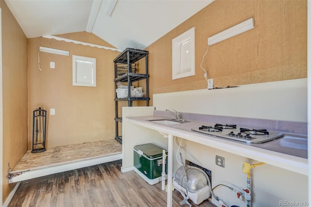 kitchen with vaulted ceiling, hardwood / wood-style floors, white gas cooktop, and sink