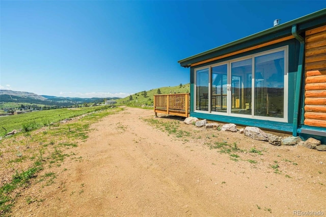 view of yard with a deck with mountain view