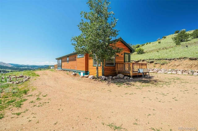 view of side of home featuring a deck with mountain view