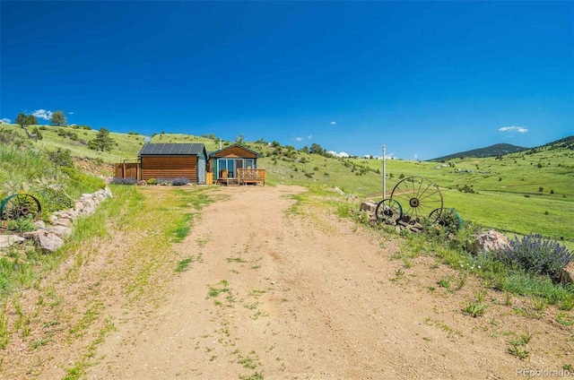 view of yard with a rural view and a wooden deck