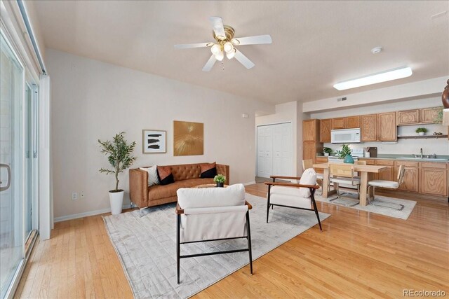 16848 E Gunnison Dr Unit 9E, Aurora, CO 80017 - living area featuring light wood finished floors, a ceiling fan, and baseboards