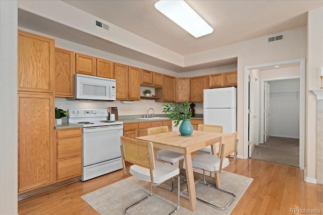 16848 E Gunnison Dr Unit 9E, Aurora, CO 80017 - kitchen featuring white appliances, light wood-style floors, a sink, and light countertops