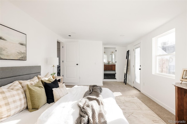 bedroom featuring light carpet and ensuite bath