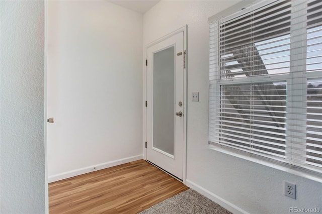 doorway to outside featuring light wood-type flooring and baseboards