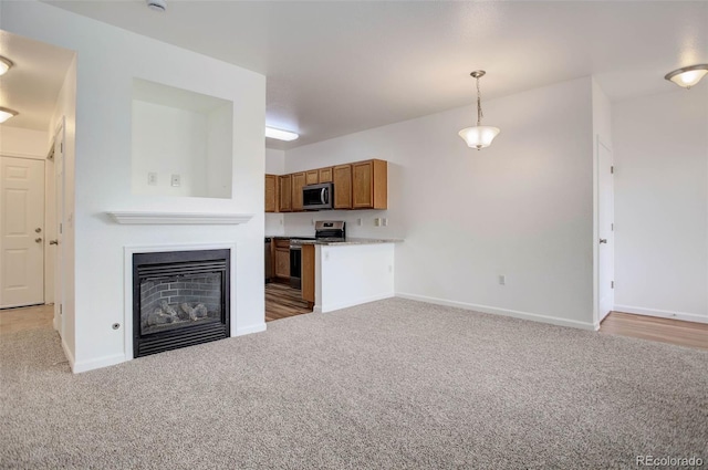 unfurnished living room with light carpet, a fireplace, and baseboards