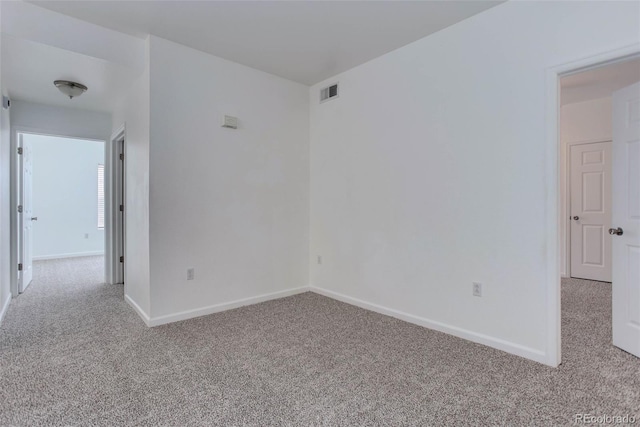 empty room with light colored carpet, visible vents, and baseboards