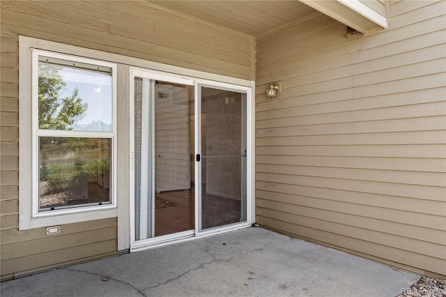 view of exterior entry with a patio area