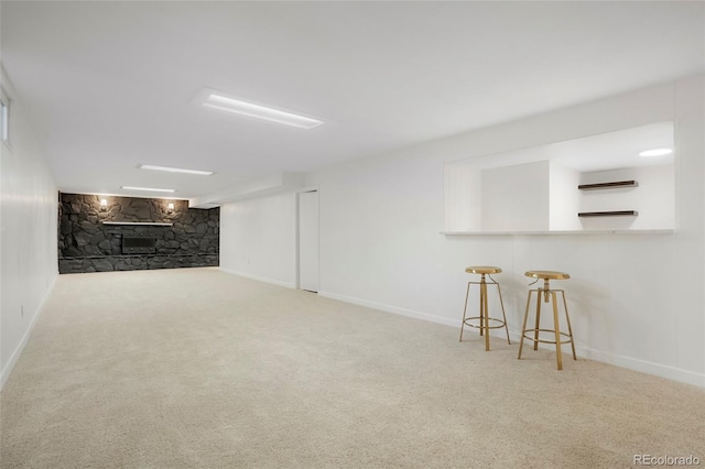 finished basement featuring carpet flooring, a fireplace, and baseboards