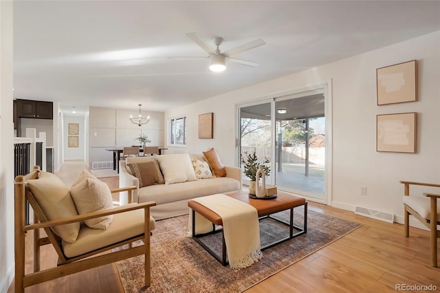 living room with light wood-type flooring, a wealth of natural light, and visible vents