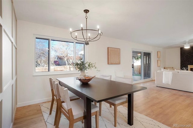 dining area featuring light wood-style flooring, baseboards, a chandelier, and a wealth of natural light