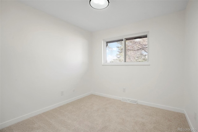 empty room with carpet floors, visible vents, and baseboards