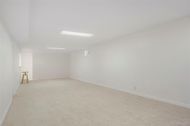 unfurnished room with baseboards and light colored carpet