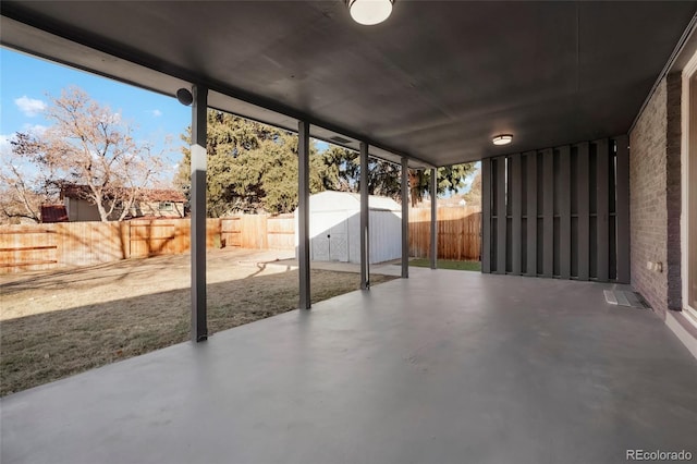 view of patio with an outbuilding, a shed, and a fenced backyard