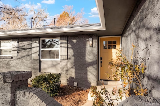 doorway to property with brick siding