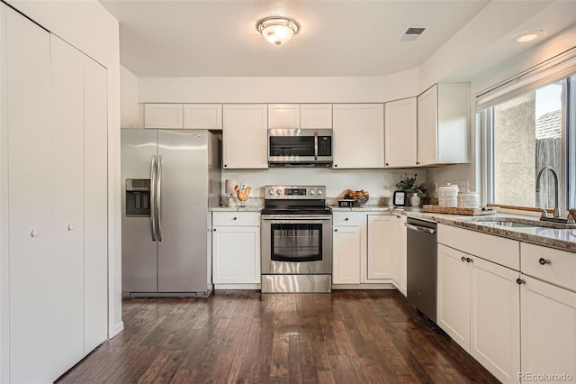 13020 E Linvale Pl, Aurora, CO 80014 - kitchen with light stone countertops, visible vents, a sink, stainless steel appliances, and dark wood-style floors