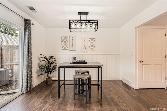 13020 E Linvale Pl, Aurora, CO 80014 - dining area with baseboards, dark wood finished floors, visible vents, and a wainscoted wall