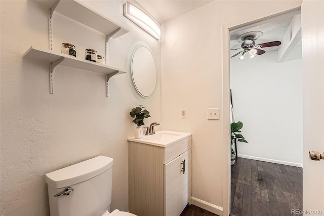 13020 E Linvale Pl, Aurora, CO 80014 - bathroom featuring toilet, wood finished floors, vanity, a ceiling fan, and baseboards