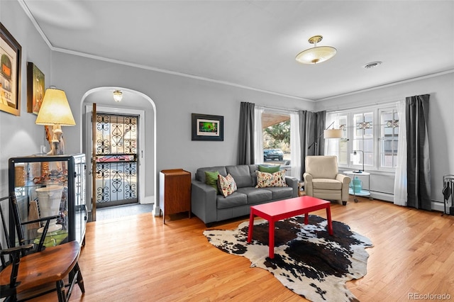 living area with arched walkways, visible vents, crown molding, and wood finished floors