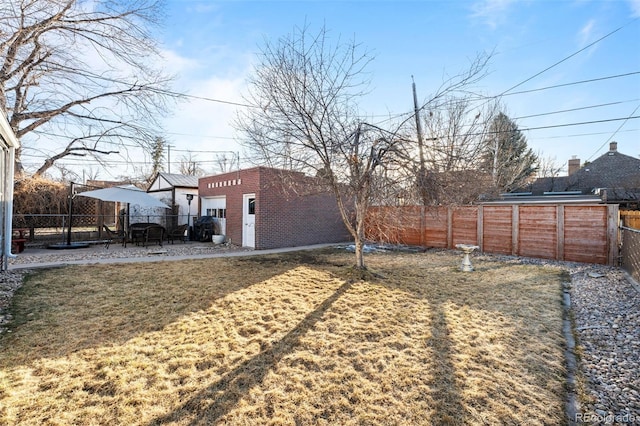 view of yard with a patio area, a fenced backyard, and an outdoor structure