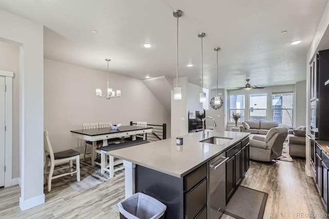 kitchen featuring sink, pendant lighting, a kitchen island with sink, and light wood-type flooring