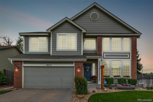 20710 E Princeton Pl, Aurora, CO 80013 - traditional home with brick siding, an attached garage, and driveway