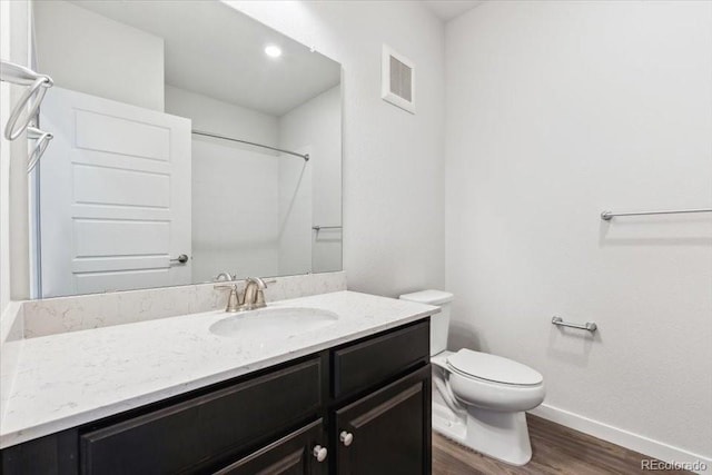 485 Interlocken Blvd Unit 201, Broomfield, CO 80021 - bathroom featuring baseboards, wood finished floors, vanity, toilet, and a shower