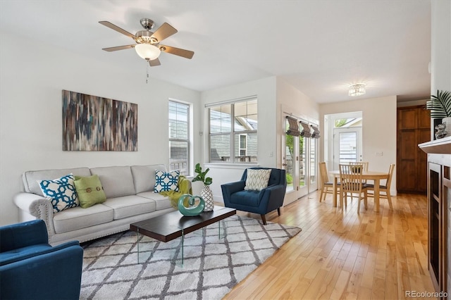 living room with light wood-type flooring and a ceiling fan