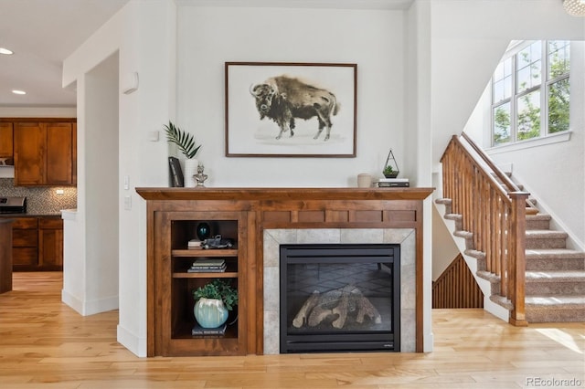 details with recessed lighting, baseboards, a tiled fireplace, decorative backsplash, and wood finished floors