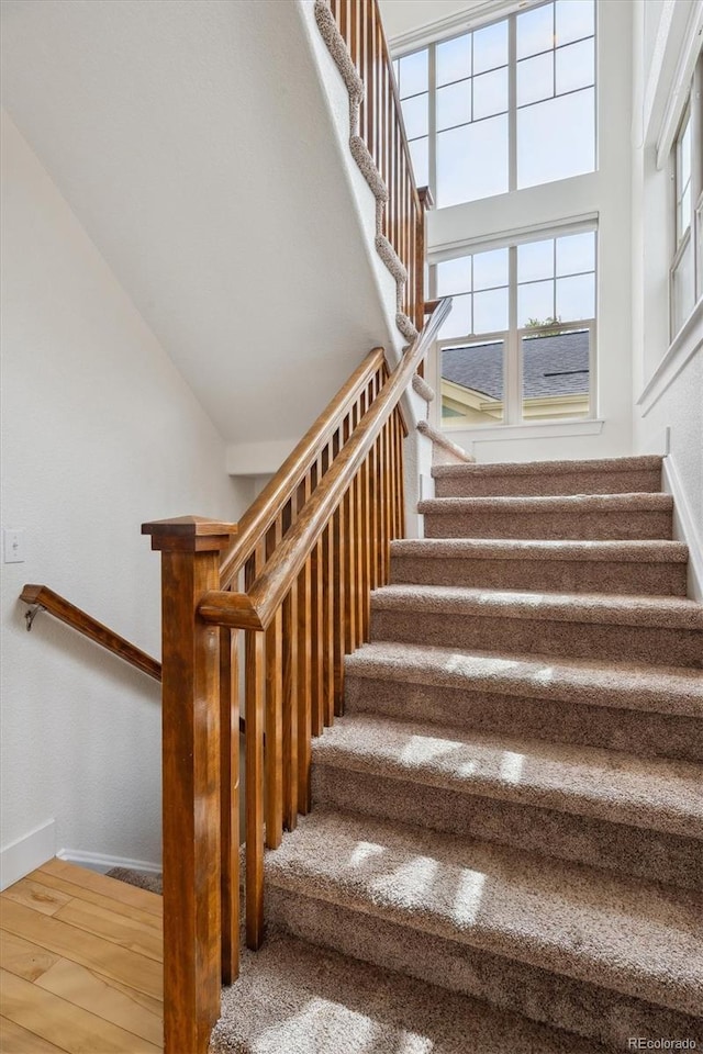 stairway with baseboards and wood finished floors