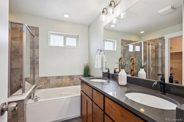 bathroom featuring a bath, visible vents, a shower stall, and a sink