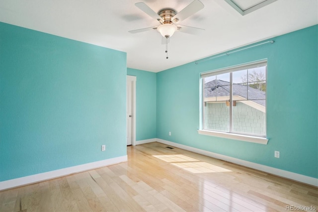 empty room featuring baseboards, a ceiling fan, and wood finished floors