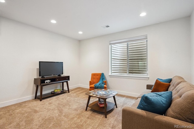 living area featuring baseboards, recessed lighting, visible vents, and light colored carpet