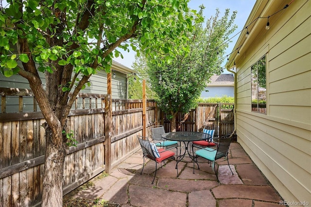 view of patio with outdoor dining area and fence