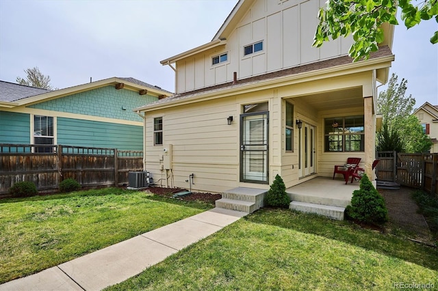 back of property featuring a yard, board and batten siding, fence, cooling unit, and a porch