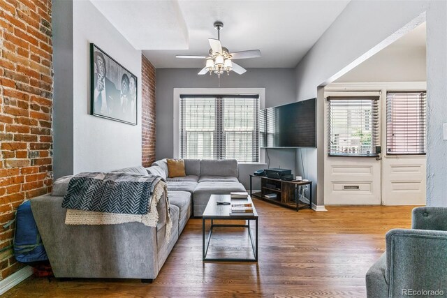 909 W Park Ave, Denver, CO 80205 - living room with wood finished floors, a ceiling fan, and brick wall
