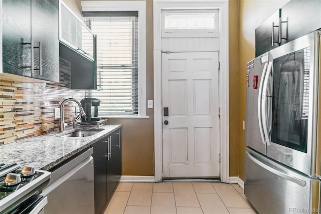 909 W Park Ave, Denver, CO 80205 - kitchen with stainless steel appliances, light tile patterned floors, light stone countertops, and decorative backsplash