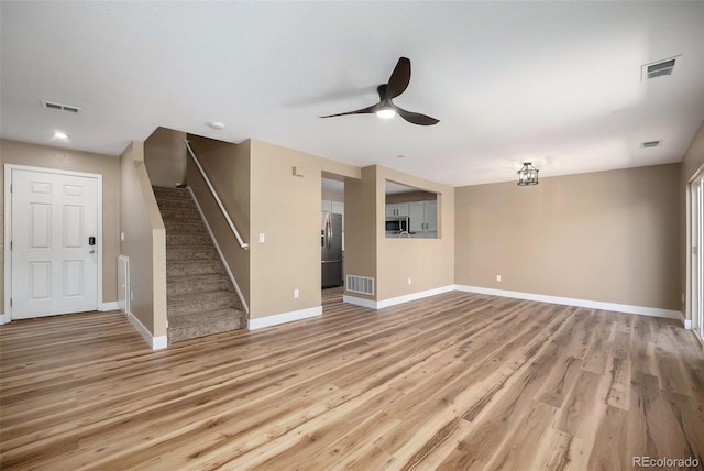 unfurnished living room with visible vents, a ceiling fan, and baseboards