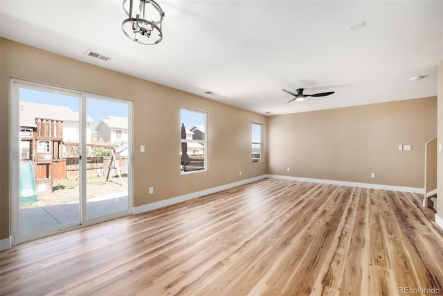 unfurnished living room featuring visible vents, light wood-style flooring, ceiling fan, and baseboards