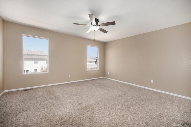 unfurnished room with carpet floors, baseboards, and a ceiling fan