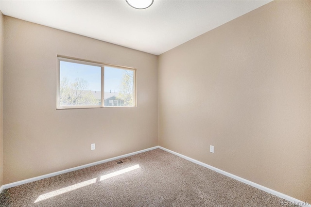 carpeted empty room featuring baseboards and visible vents