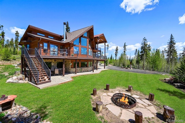 back of property with a patio, stairway, a yard, a fire pit, and stone siding