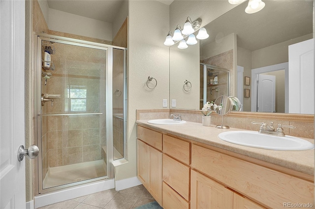 bathroom with tile patterned floors, a shower with door, and vanity