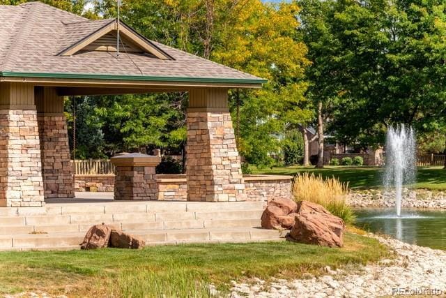 surrounding community featuring a water view and a lawn