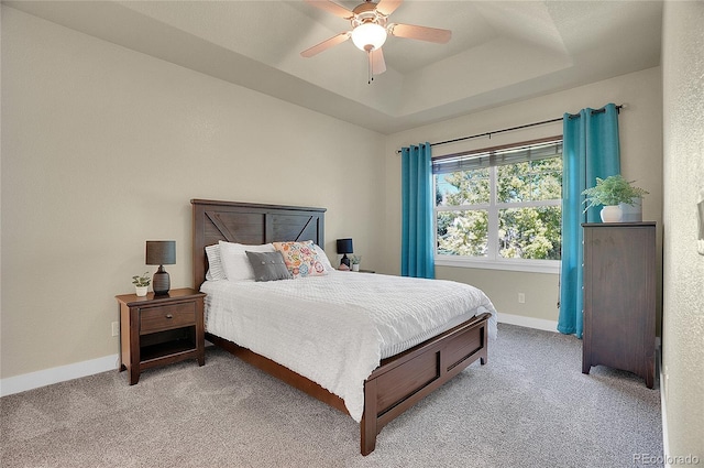 bedroom with a tray ceiling, ceiling fan, and light colored carpet